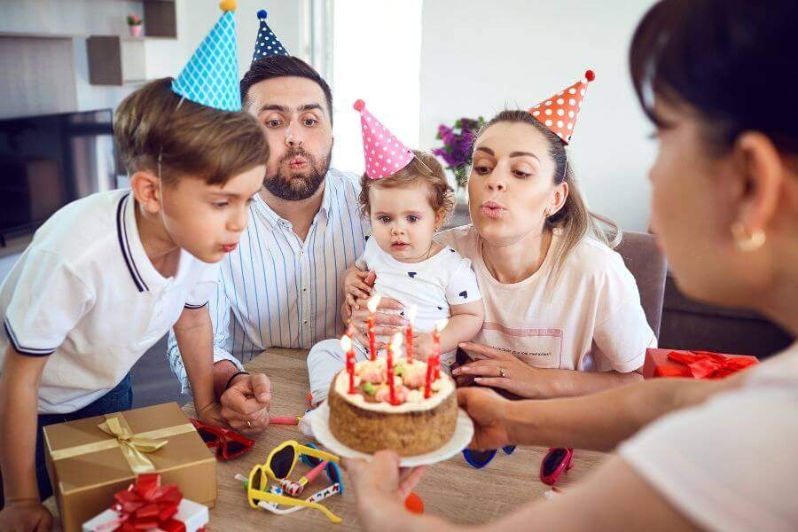 rodzina dmuchajaca tort urodzinowy